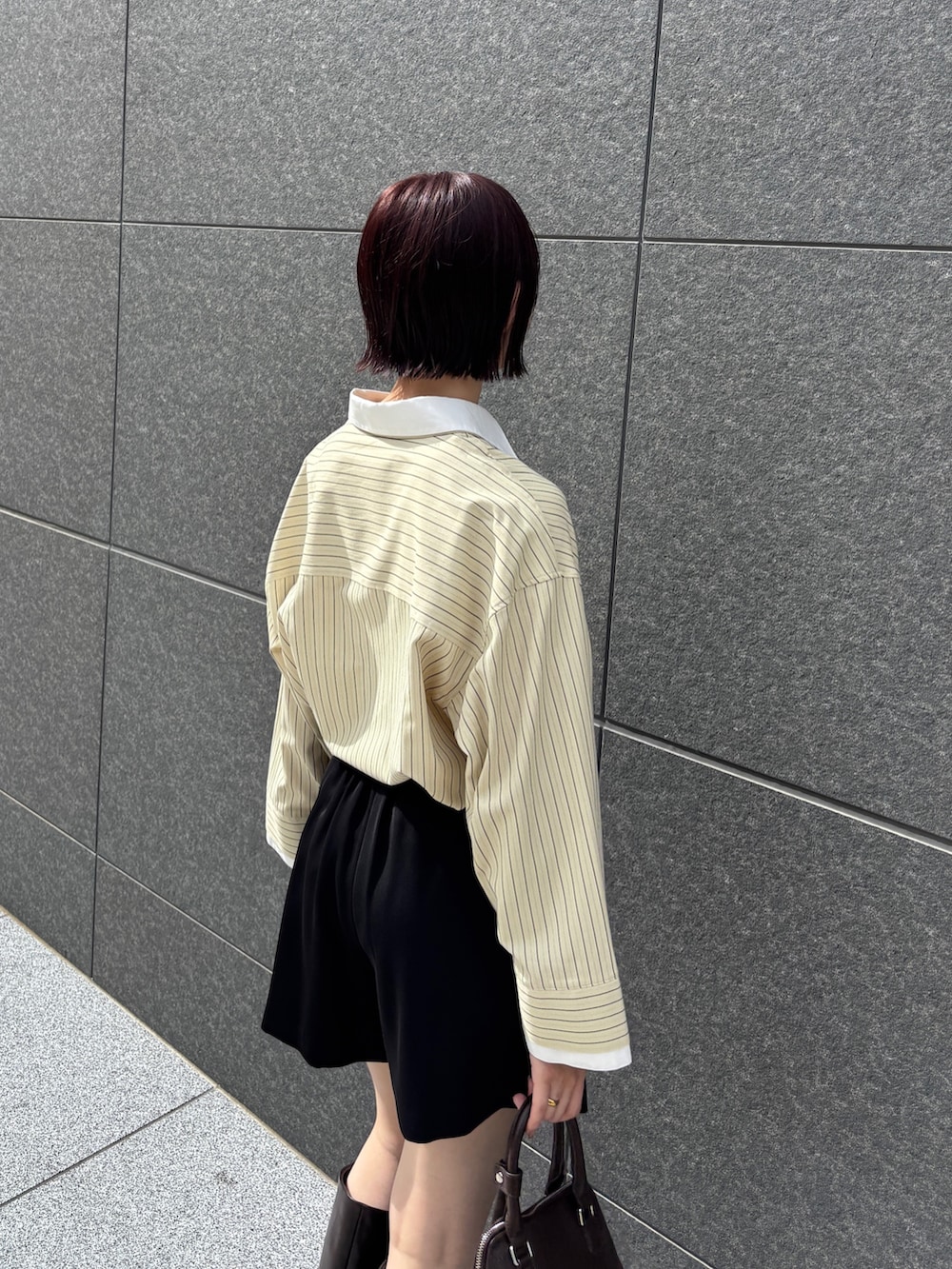 イエロー系のシャツ/ブラウス、ブラック系のその他パンツ、ブラウン系のブーツを着用したレディースの秋コーディネートの6枚目の写真