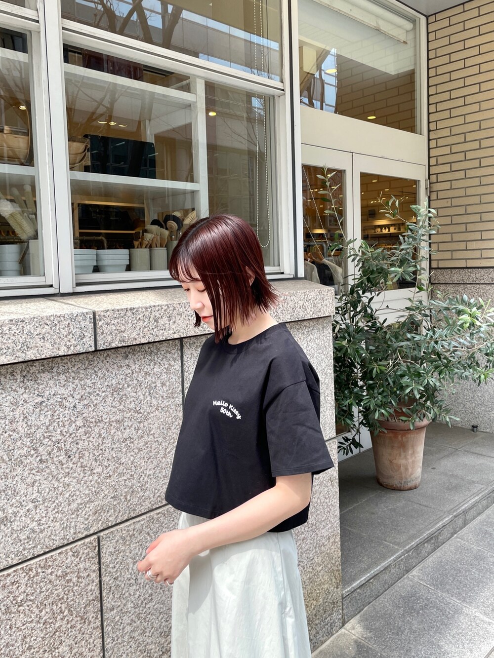 シルバー系のパンプス、ブラック系のTシャツ/カットソー、ホワイト系のスカートを着用したレディースの春コーディネートの7枚目の写真