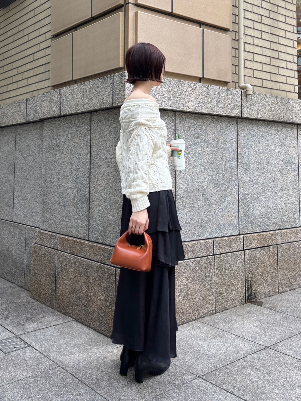 ホワイト系のニット/セーター、ブラック系のスカート、ブラウン系のハンドバッグを着用したレディースの秋コーディネートの3枚目の写真