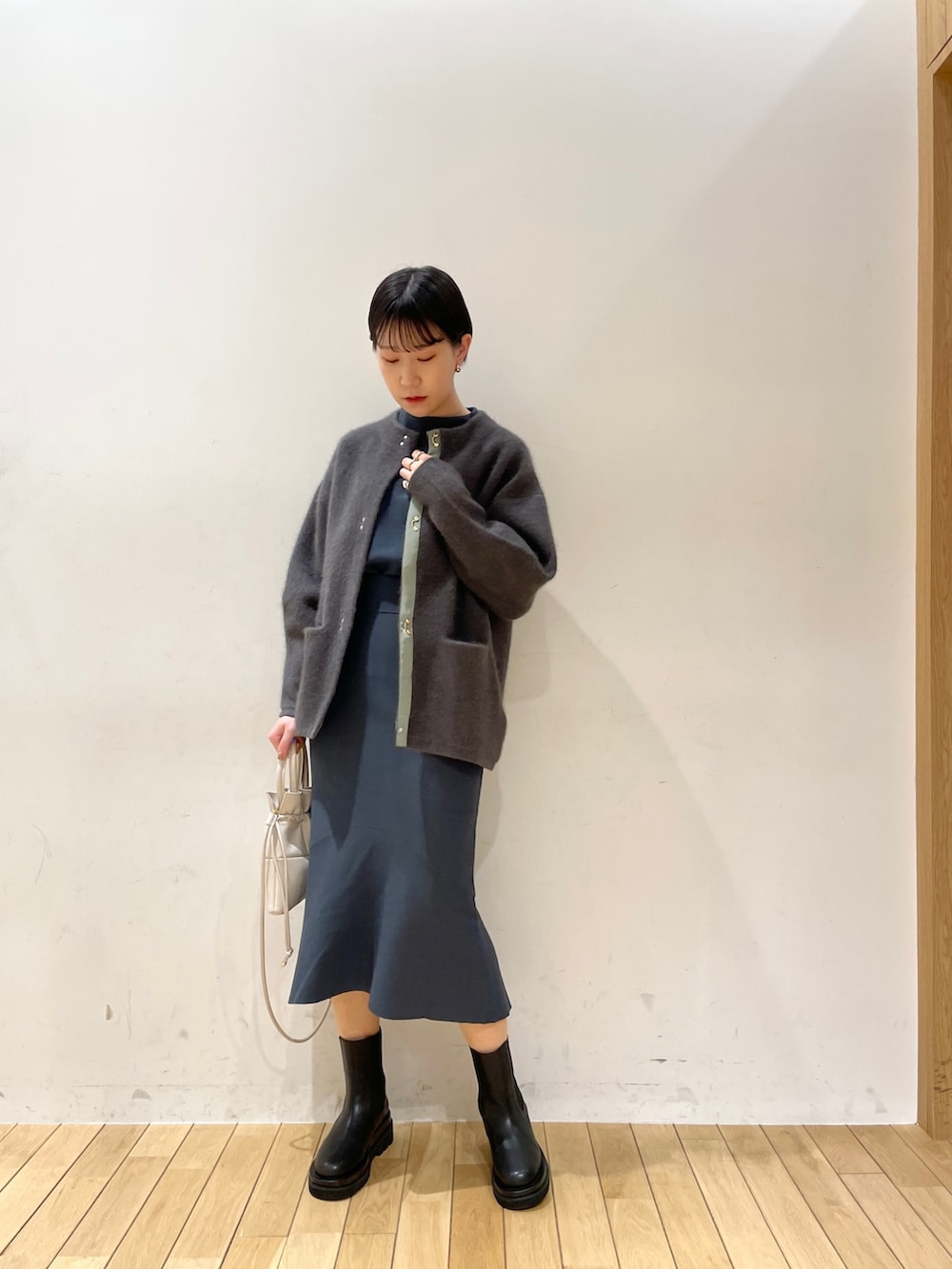 グリーン系のスカート、グリーン系のニット/セーター、ブラック系のブーツを着用したレディースの冬コーディネートの8枚目の写真