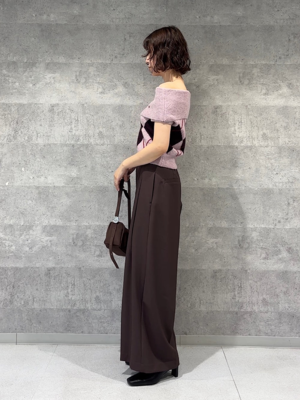 ブラウン系のその他パンツ、ブラウン系のハンドバッグ、ブラック系のブーツを着用したレディースの秋コーディネートの2枚目の写真
