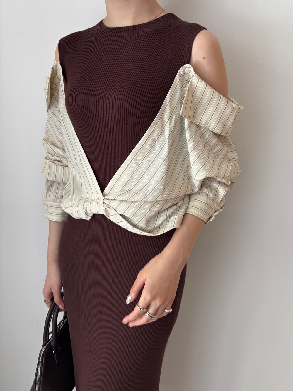 ブラウン系のワンピース、ブラウン系のボストンバッグ、ブラウン系のパンプスを着用したレディースの秋コーディネートの7枚目の写真