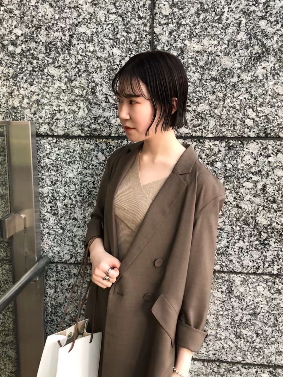 ベージュ系のニット/セーター、ホワイト系のスニーカー、ホワイト系のスカートを着用したレディースの春コーディネートの2枚目の写真