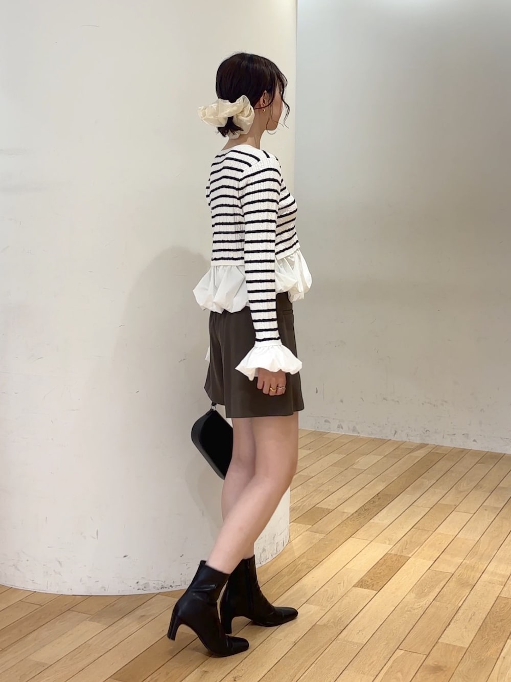 ブラウン系のその他パンツ、ブラック系のハンドバッグ、ブラック系のブーツを着用したレディースの夏コーディネートの3枚目の写真