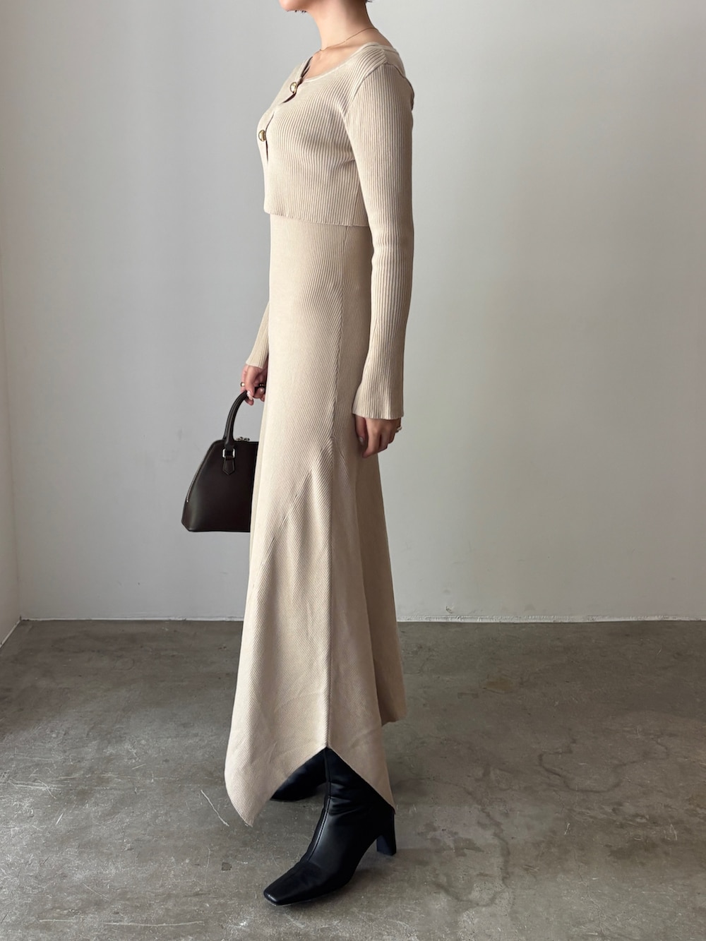 ホワイト系のワンピース、ブラウン系のボストンバッグ、ブラック系のブーツを着用したレディースの秋コーディネートの2枚目の写真