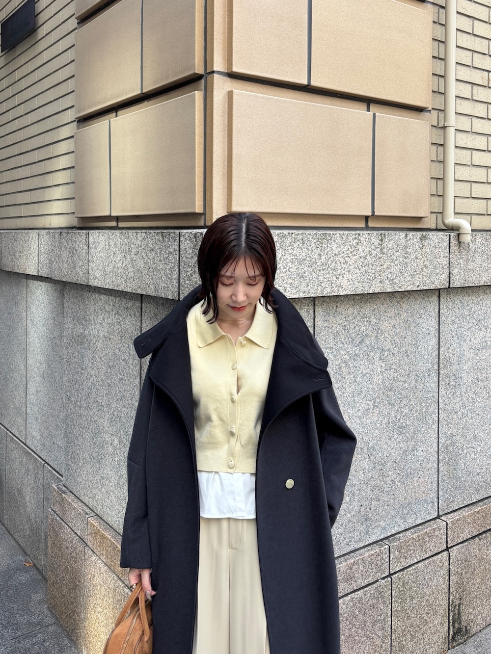 ベージュ系のその他パンツ、イエロー系のカーディガン/ボレロ、イエロー系のハンドバッグを着用したレディースの秋コーディネートの5枚目の写真