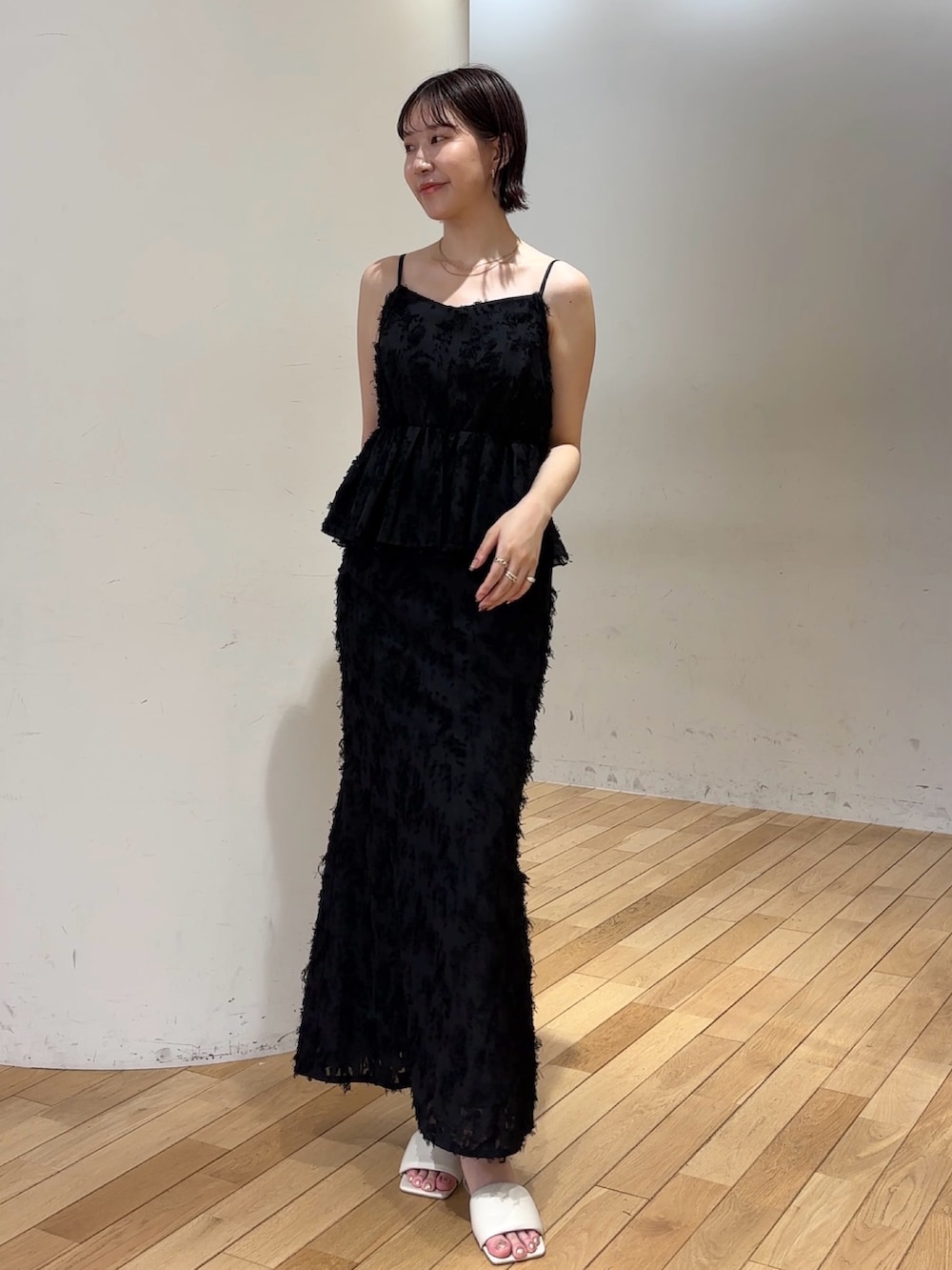 ブラック系のハンドバッグ、ブラック系のスカート、ブラック系のシャツ/ブラウスを着用したレディースの夏コーディネートの6枚目の写真