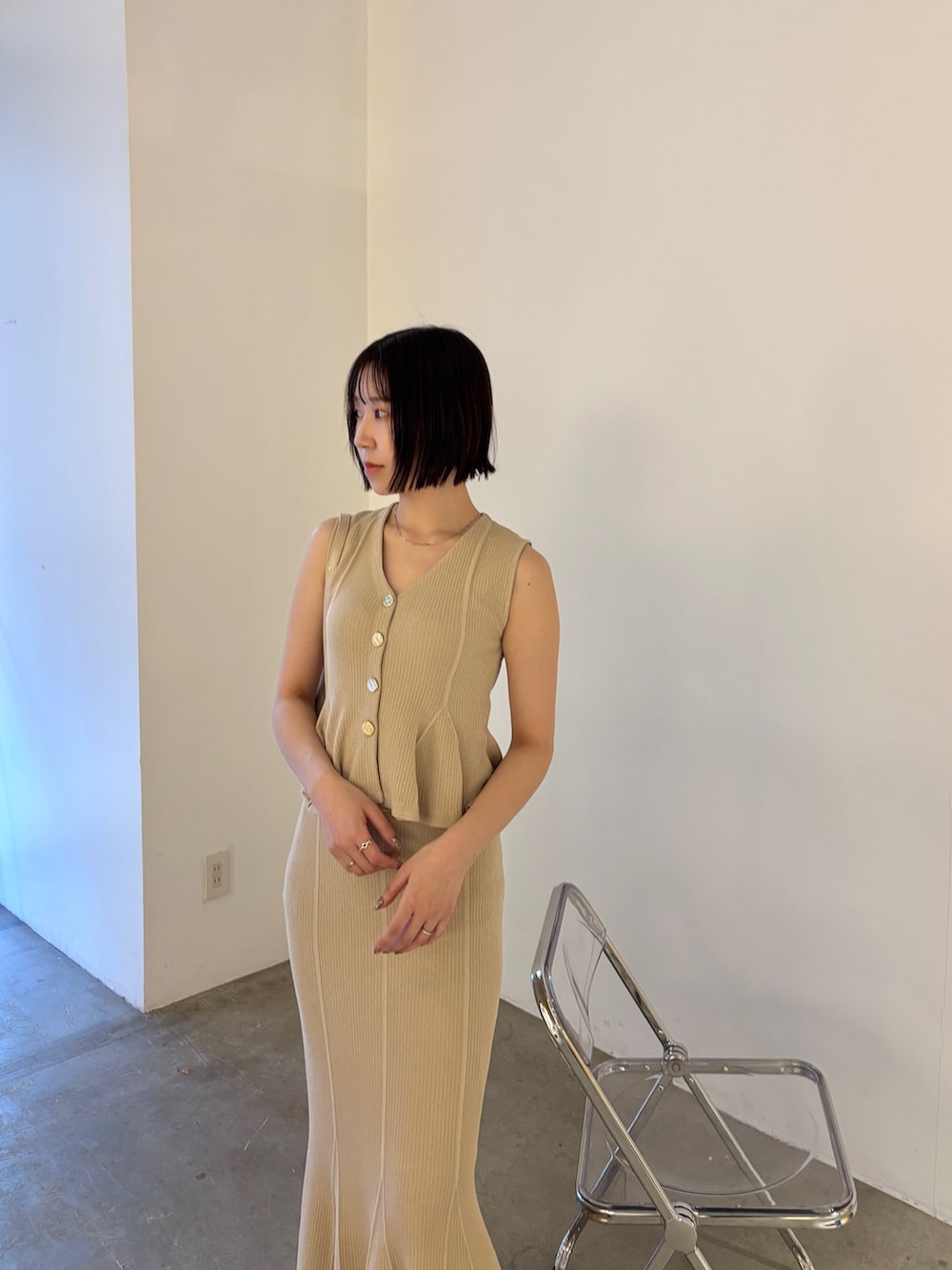 ベージュ系のニット/セーター、ベージュ系のスカート、ブラック系のパンプスを着用したレディースの春コーディネートの4枚目の写真