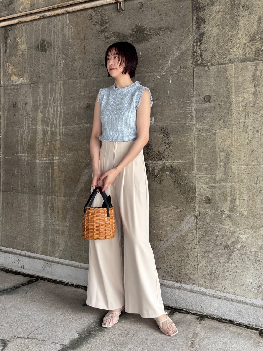 ホワイト系のその他パンツ、ブラウン系のハンドバッグ、ブルー系のニット/セーターを着用したレディースの夏コーディネートの2枚目の写真