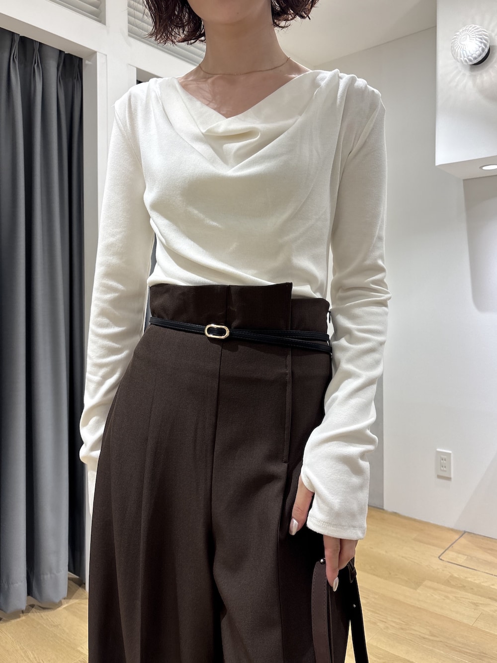 ブラウン系のその他パンツ、ホワイト系のニット/セーター、ブラウン系のハンドバッグを着用したレディースの秋コーディネートの5枚目の写真