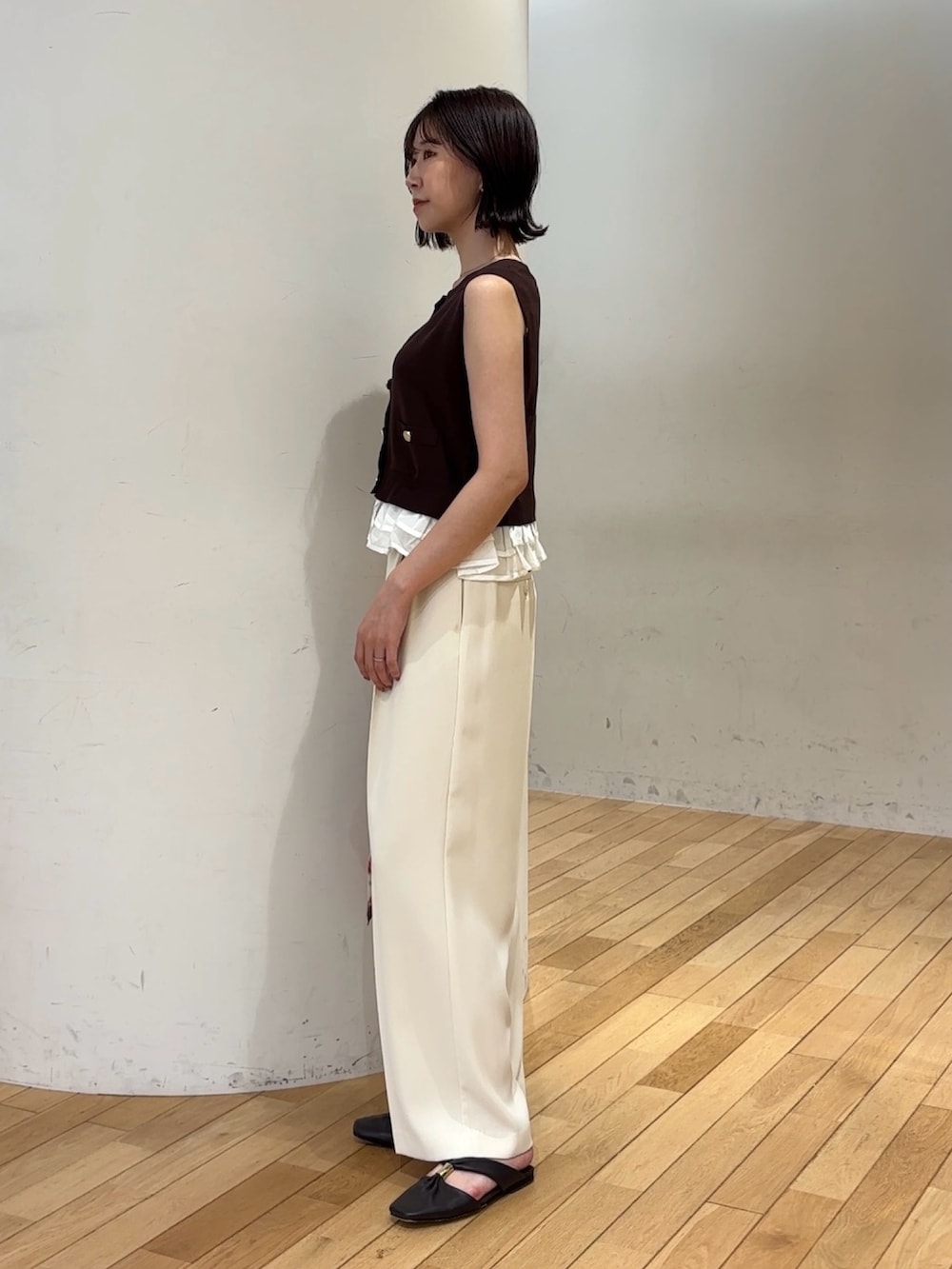 ブラウン系のニット/セーター、ホワイト系のその他パンツ、ブラウン系のハンドバッグを着用したレディースの夏コーディネートの2枚目の写真