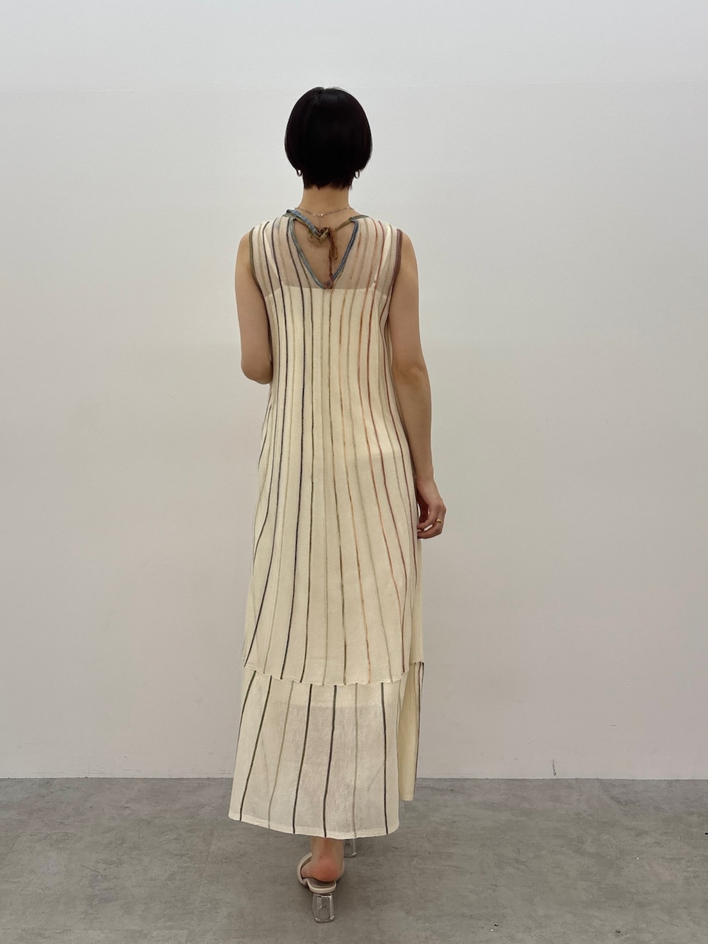 ホワイト系のワンピース、ホワイト系のサンダル、シルバー系のネックレスを着用したレディースの春コーディネートの4枚目の写真