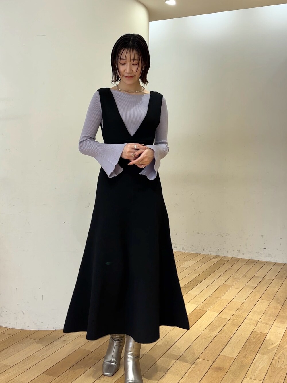 ブラック系のジャンパースカート、パープル系のニット/セーター、シルバー系のブーツを着用したレディースの冬コーディネートの3枚目の写真