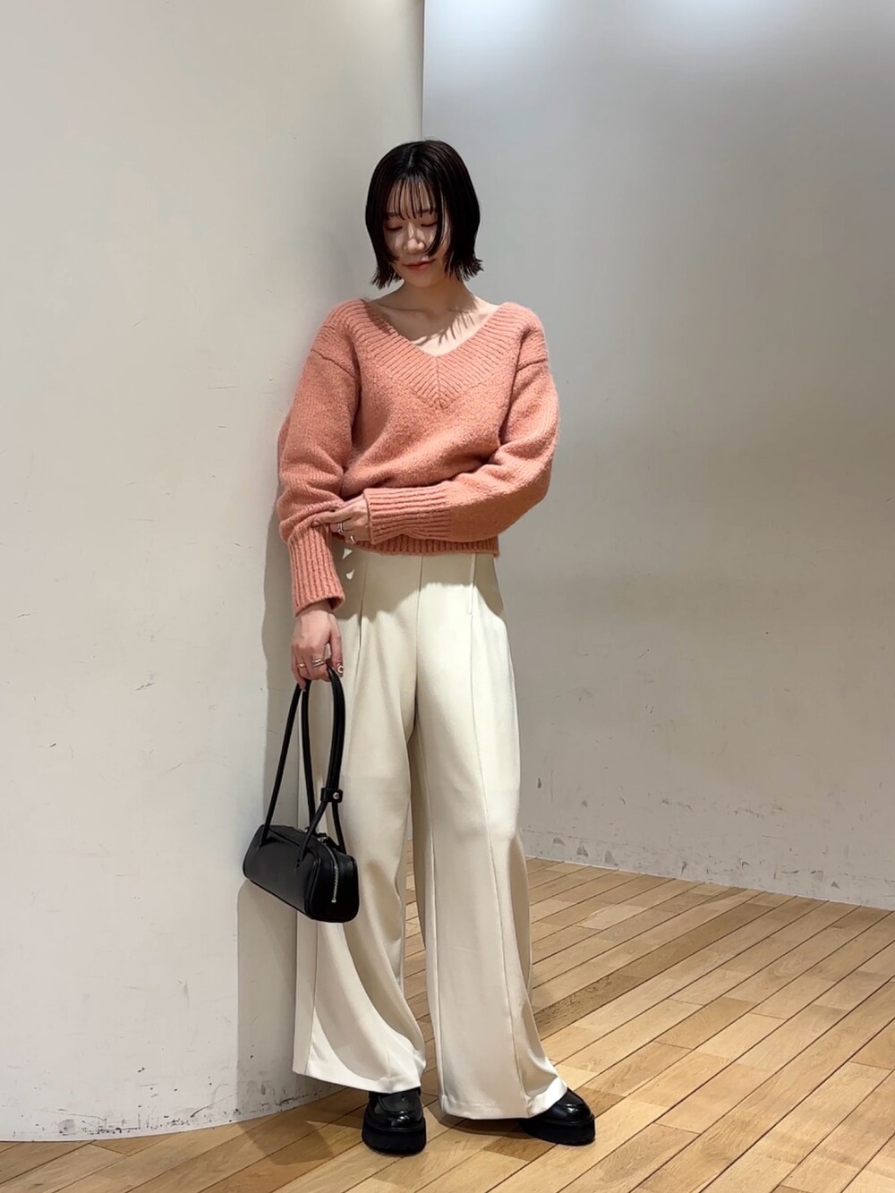 ピンク系のニット/セーター、ブラック系のショルダーバッグ、ホワイト系のその他パンツを着用したレディースの冬コーディネートの2枚目の写真