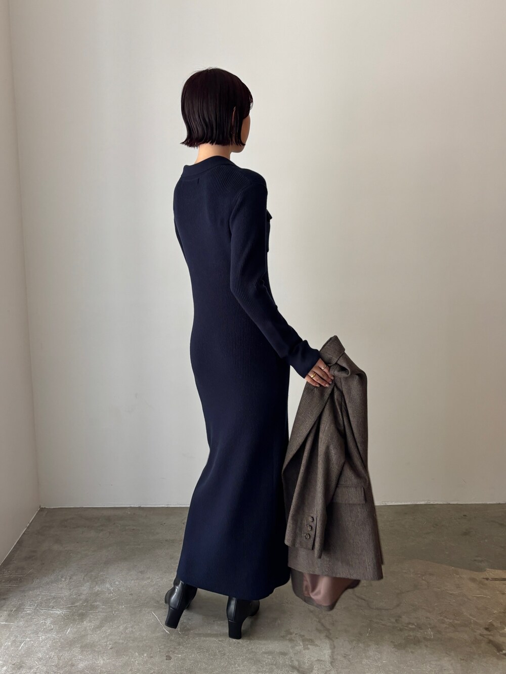 ブルー系のワンピース、ブラウン系のテーラードジャケット、ブラック系のブーツを着用したレディースの秋コーディネートの3枚目の写真