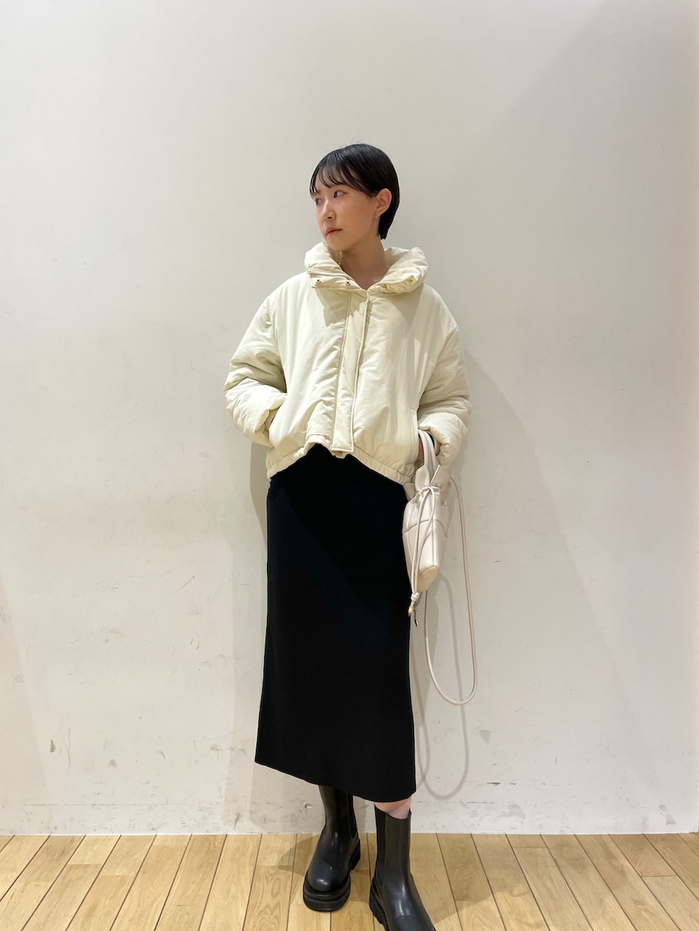 ホワイト系のダウンジャケット/コート、ブラック系のワンピース、ブラック系のブーツを着用したレディースの冬コーディネートの4枚目の写真