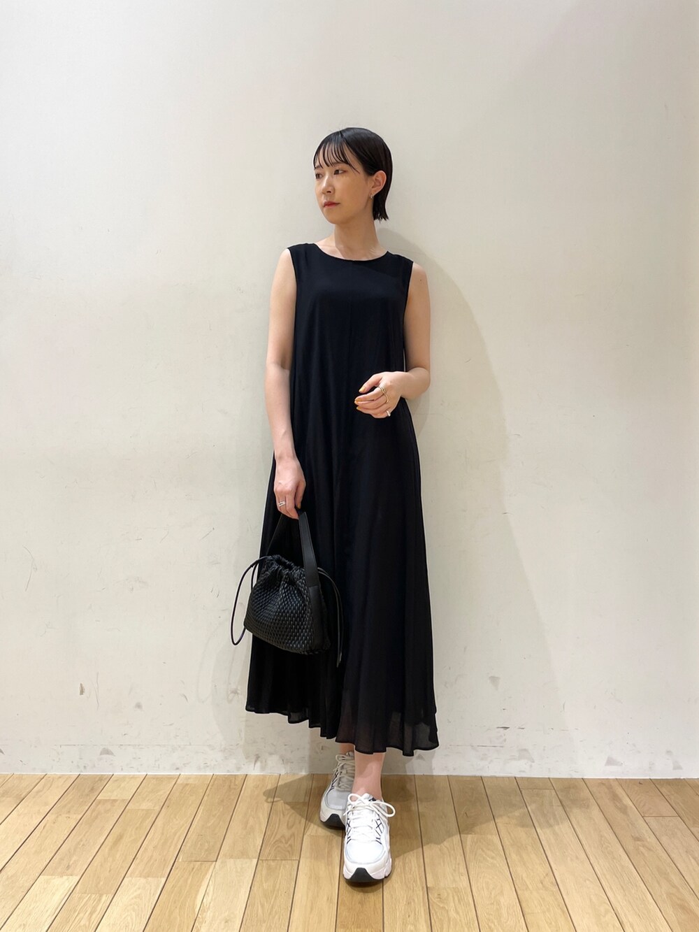 ブラック系のハンドバッグ、ベージュ系のテーラードジャケット、ブラック系のワンピースを着用したレディースの夏コーディネートの3枚目の写真