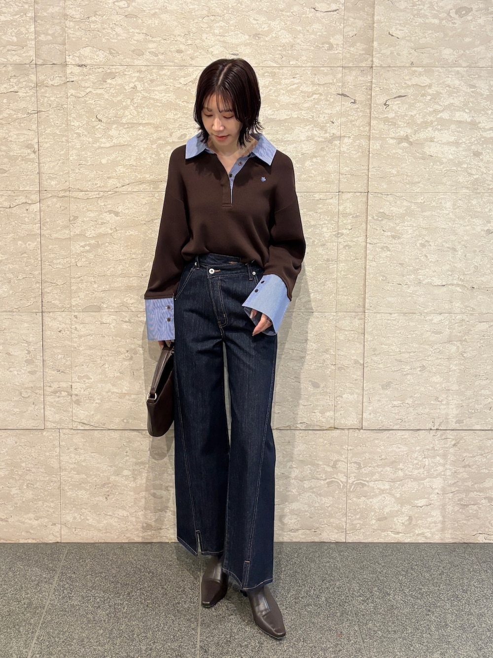 ブルー系のデニムパンツ、ブラウン系のニット/セーター、ブラウン系のハンドバッグを着用したレディースの冬コーディネートの7枚目の写真