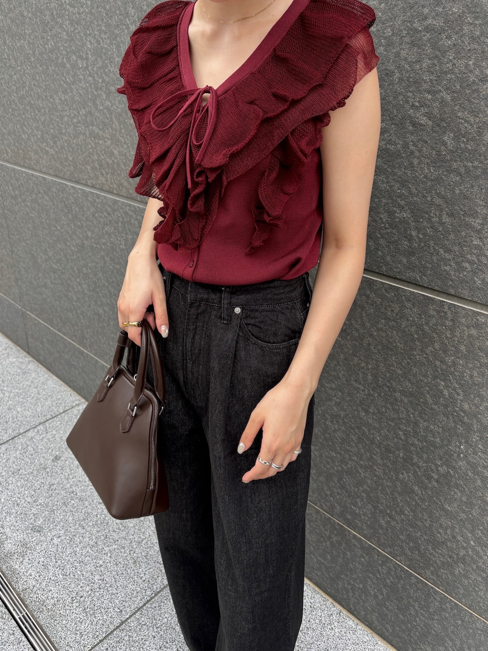 ブラウン系のボストンバッグ、ブラック系のデニムパンツ、ブラウン系のパンプスを着用したレディースの夏コーディネートの7枚目の写真