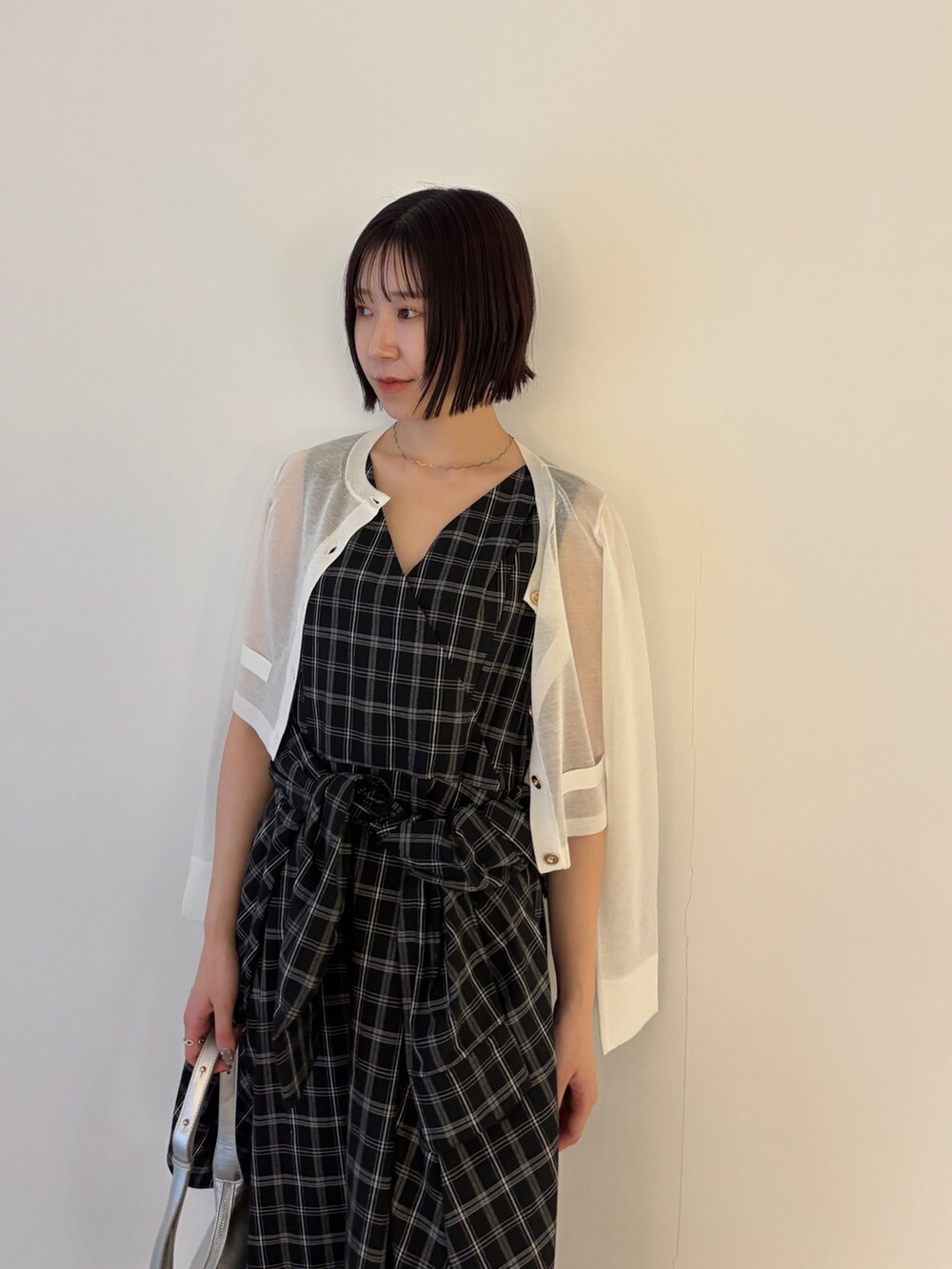 ホワイト系のカーディガン/ボレロ、シルバー系のパンプス、シルバー系のハンドバッグを着用したレディースの春コーディネートの3枚目の写真