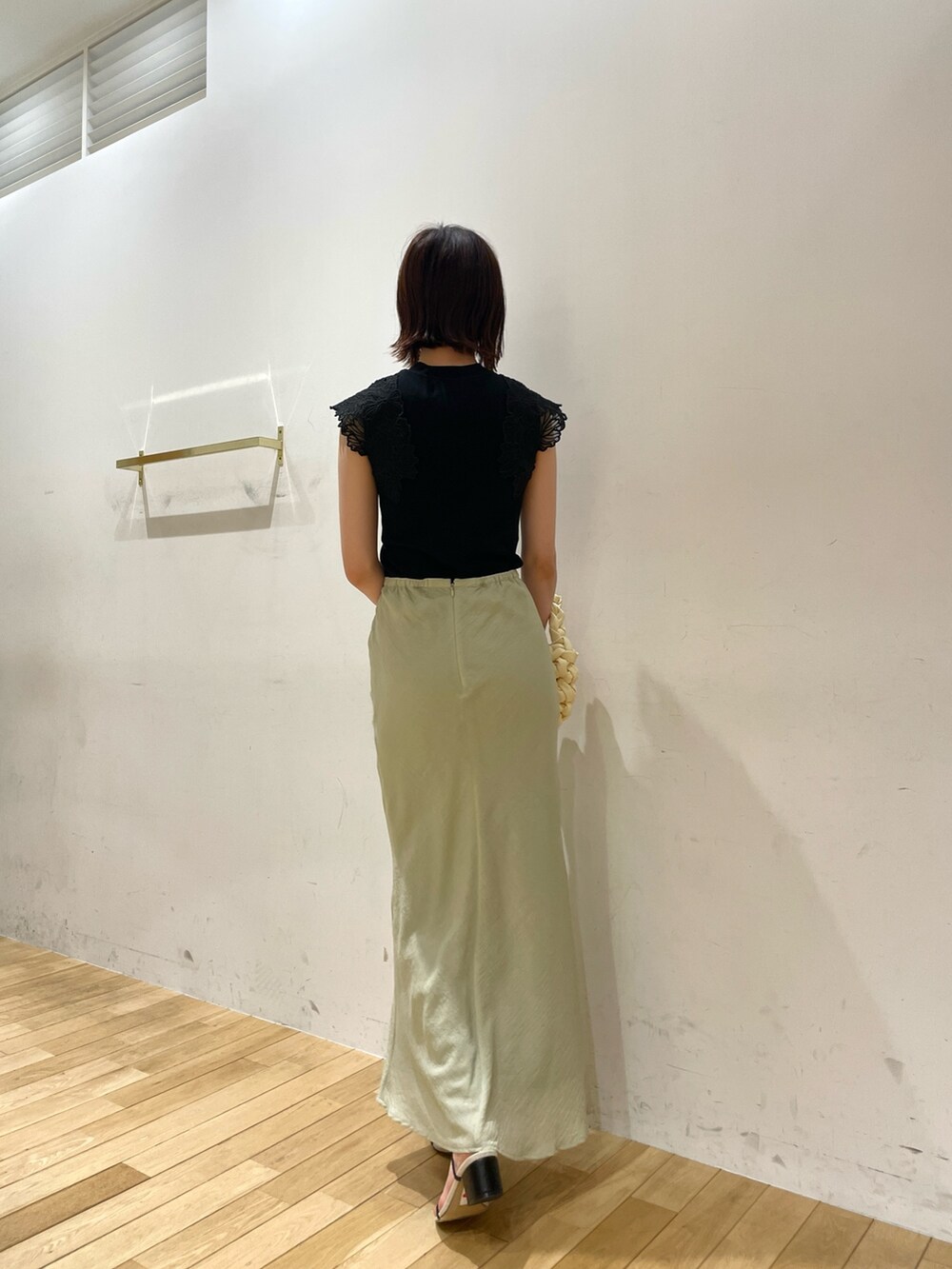 ベージュ系のハンドバッグ、ブラック系のサンダル、グリーン系のスカートを着用したレディースの夏コーディネートの5枚目の写真