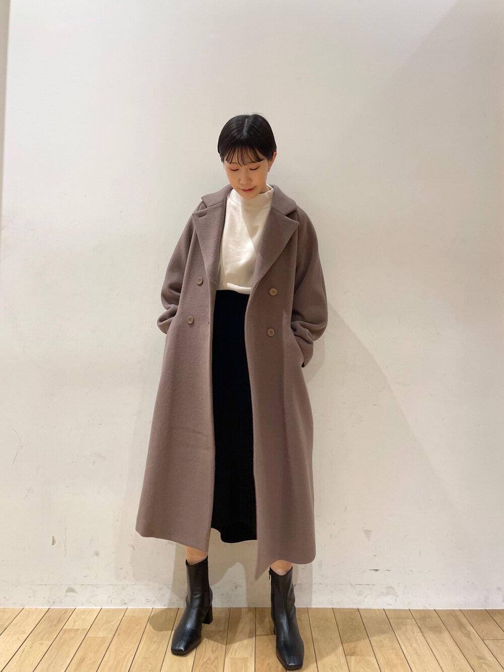 ホワイト系のニット/セーター、ブラック系のスカート、ブラック系のブーツを着用したレディースの冬コーディネートの3枚目の写真