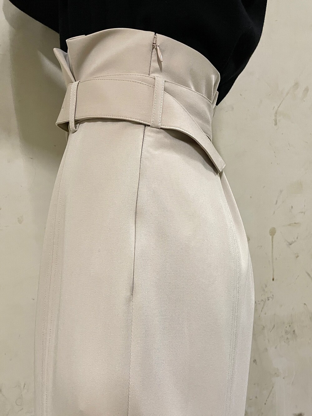 ベージュ系のスカート、ブラック系のニット/セーター、ブラック系のブーツを着用したレディースの秋コーディネートの8枚目の写真