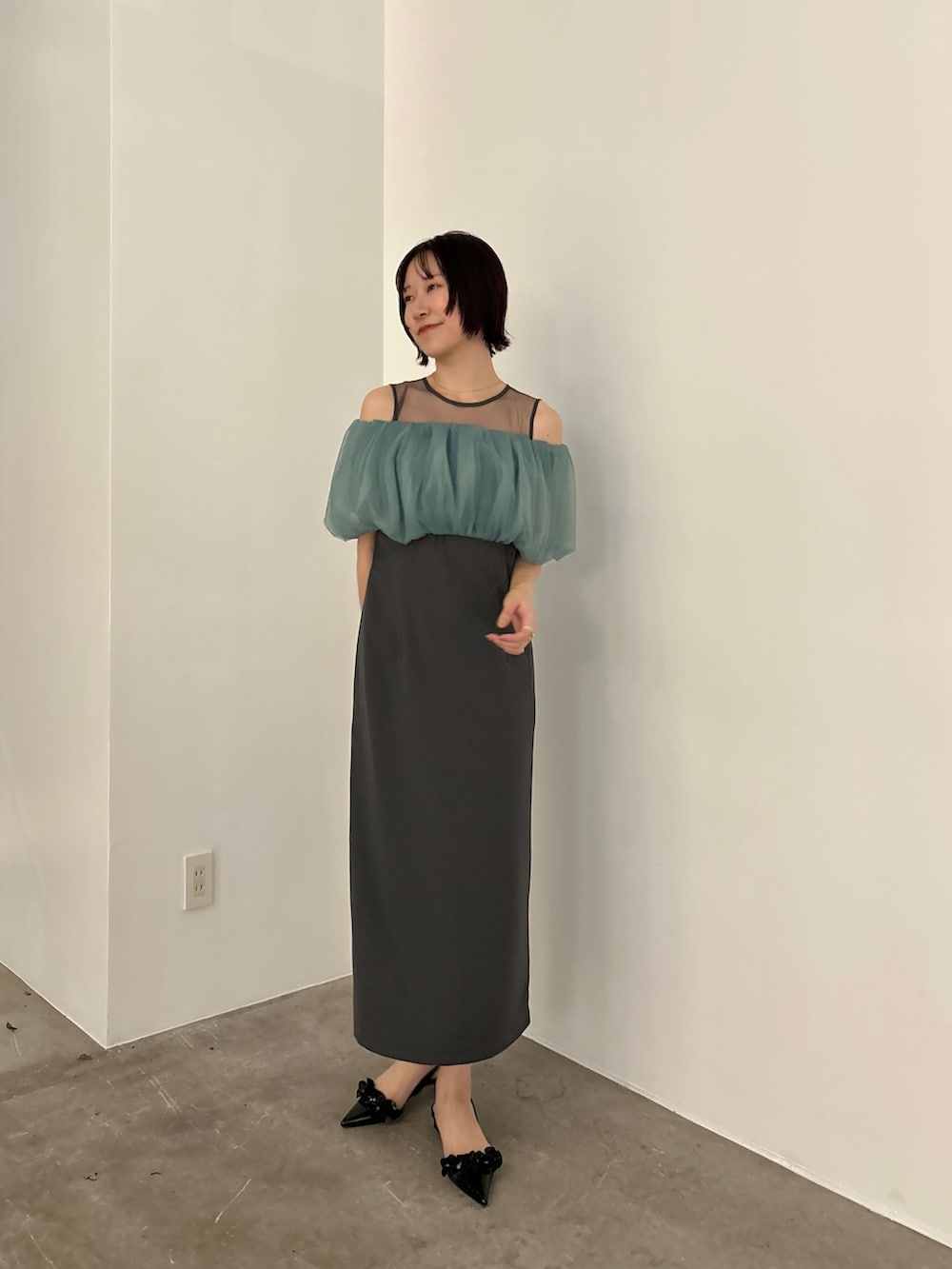 グレー系のドレス、ブラック系のパンプスを着用したレディースの冬コーディネートの2枚目の写真