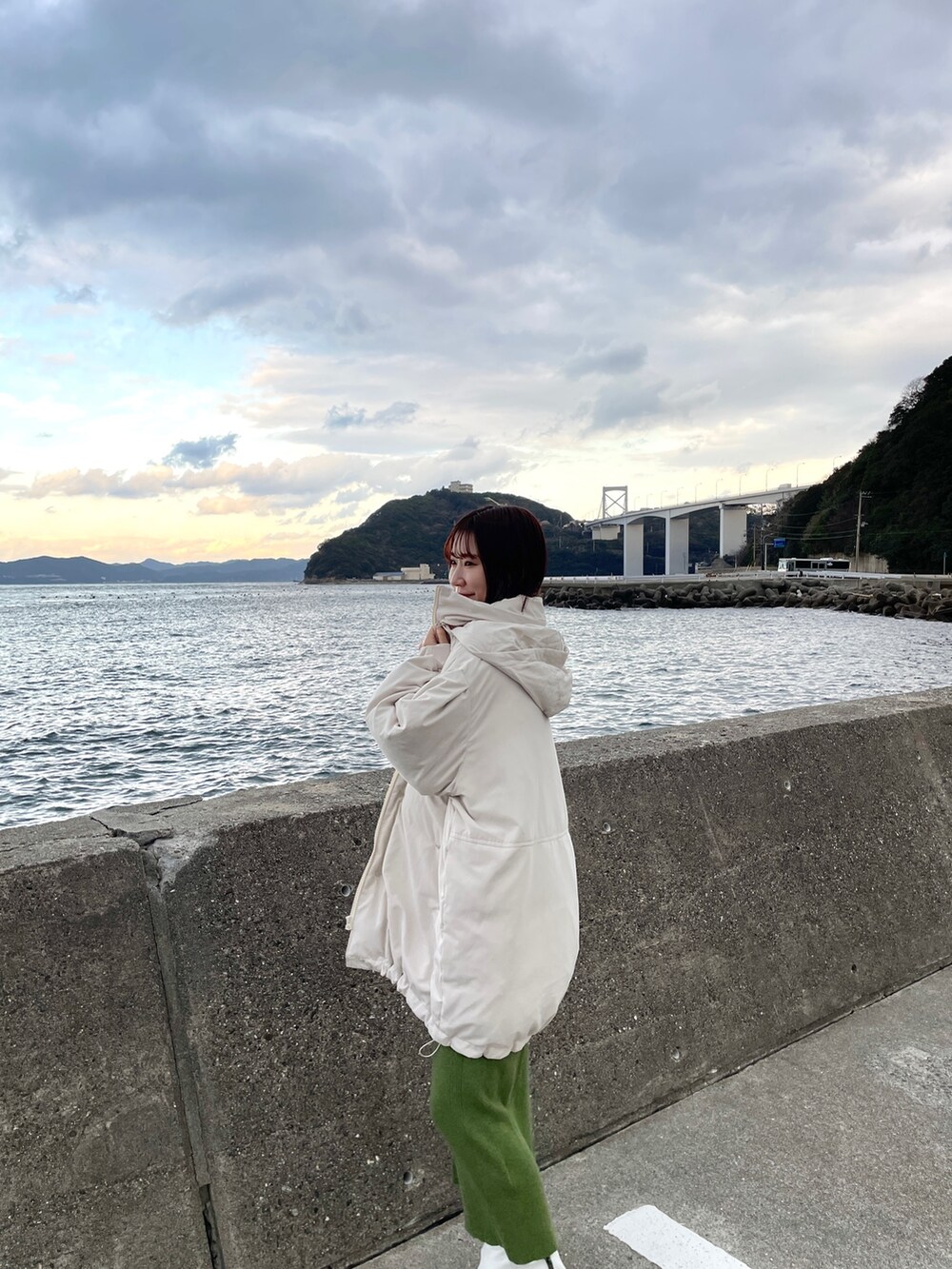 グリーン系のワンピース、ホワイト系のダウンジャケット/コートを着用したレディースの冬コーディネートの5枚目の写真