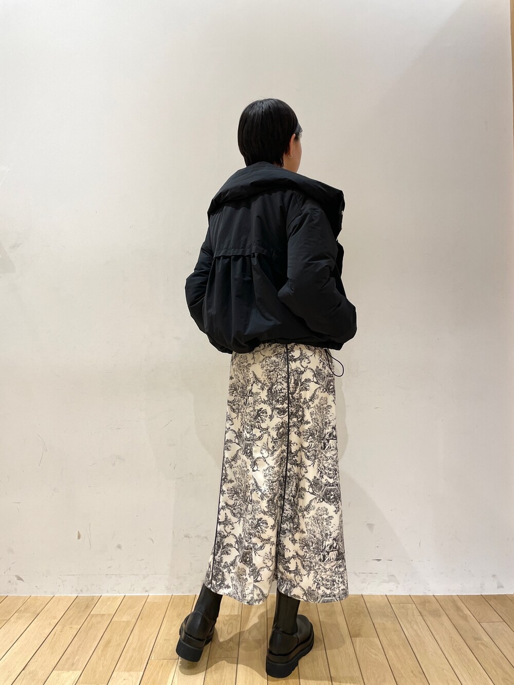 ホワイト系のワンピース、ブラック系のブーツ、ホワイト系のハンドバッグを着用したレディースの冬コーディネートの6枚目の写真