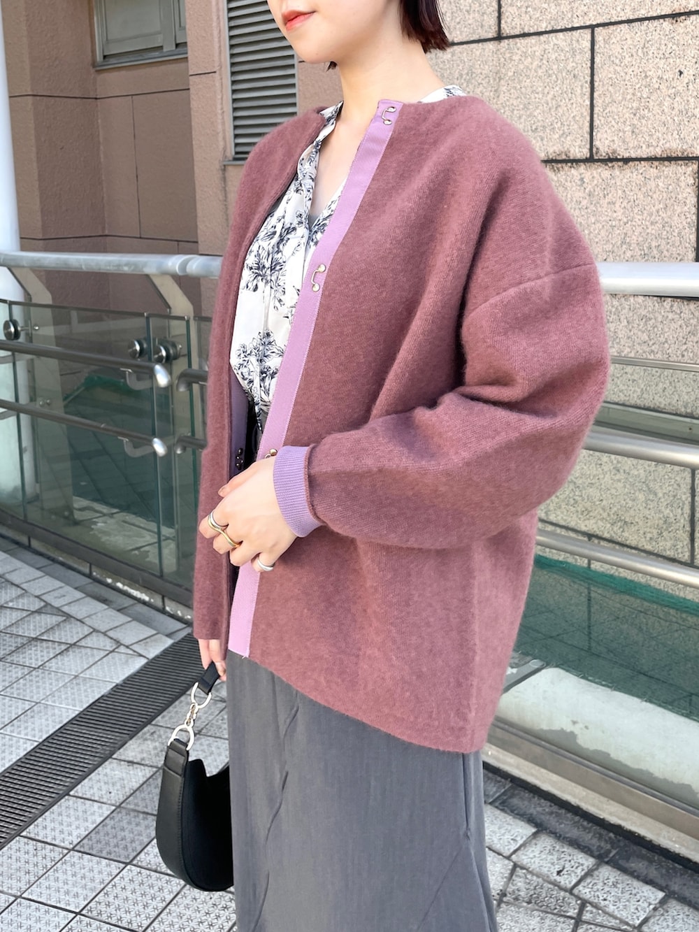 ピンク系のカーディガン/ボレロ、グレー系のスカート、ホワイト系のシャツ/ブラウスを着用したレディースの秋コーディネートの5枚目の写真