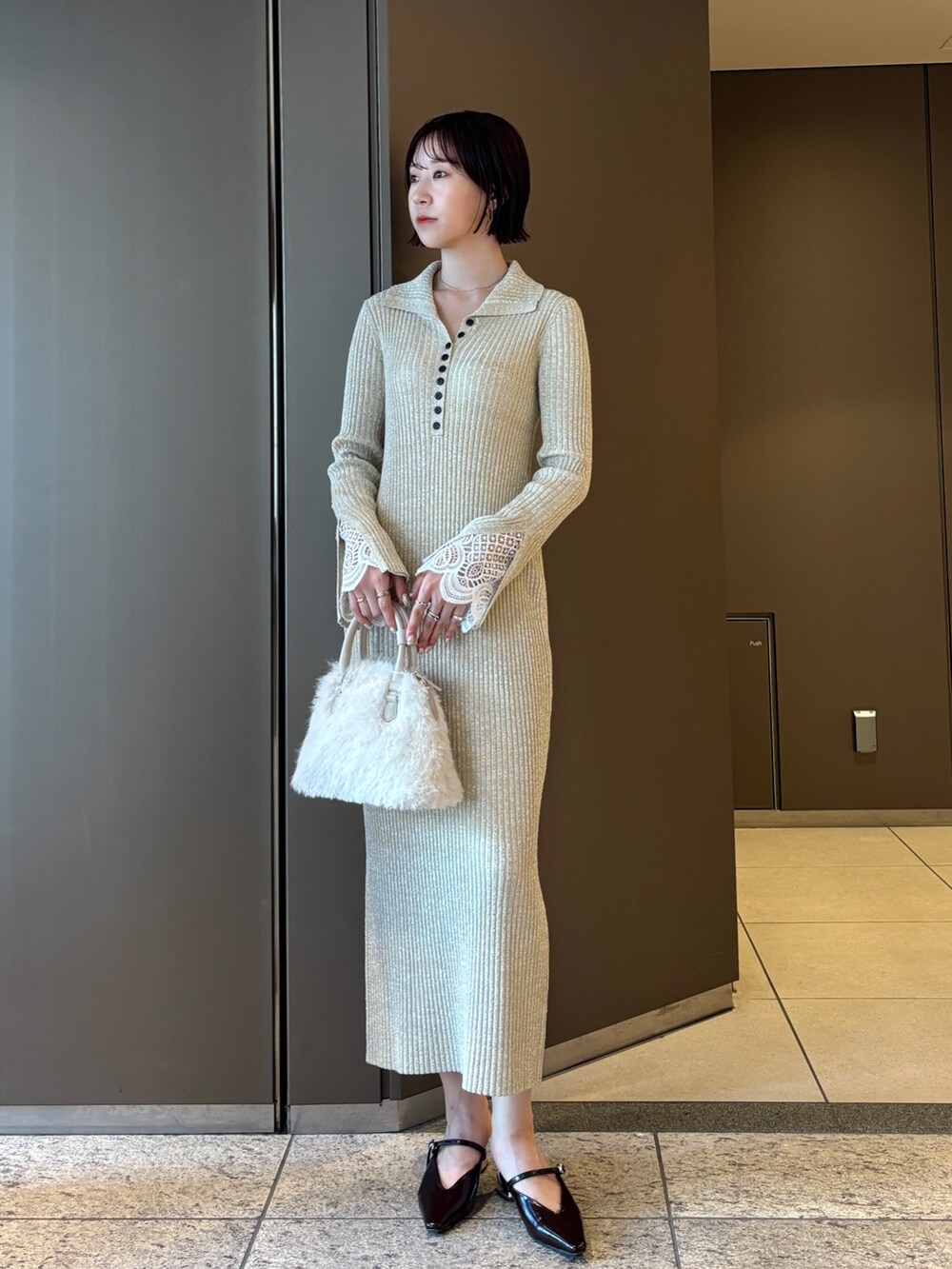 ベージュ系のワンピース、ホワイト系のボストンバッグ、ブラウン系のパンプスを着用したレディースの秋コーディネートの2枚目の写真