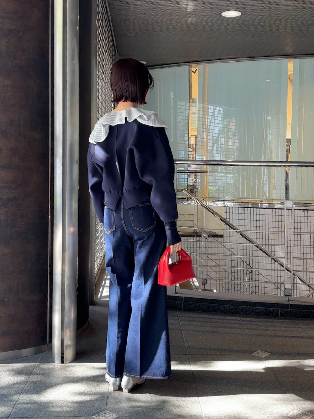 ホワイト系のシャツ/ブラウス、ブルー系のカーディガン/ボレロ、レッド系のハンドバッグを着用したレディースの冬コーディネートの4枚目の写真