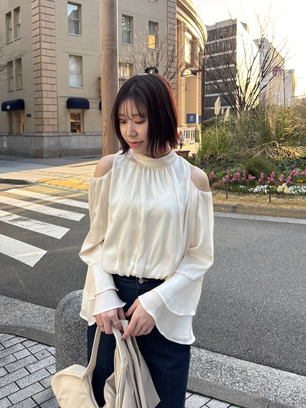 ホワイト系のシャツ/ブラウス、ホワイト系のハンドバッグ、ベージュ系のテーラードジャケットを着用したレディースの春コーディネートの8枚目の写真