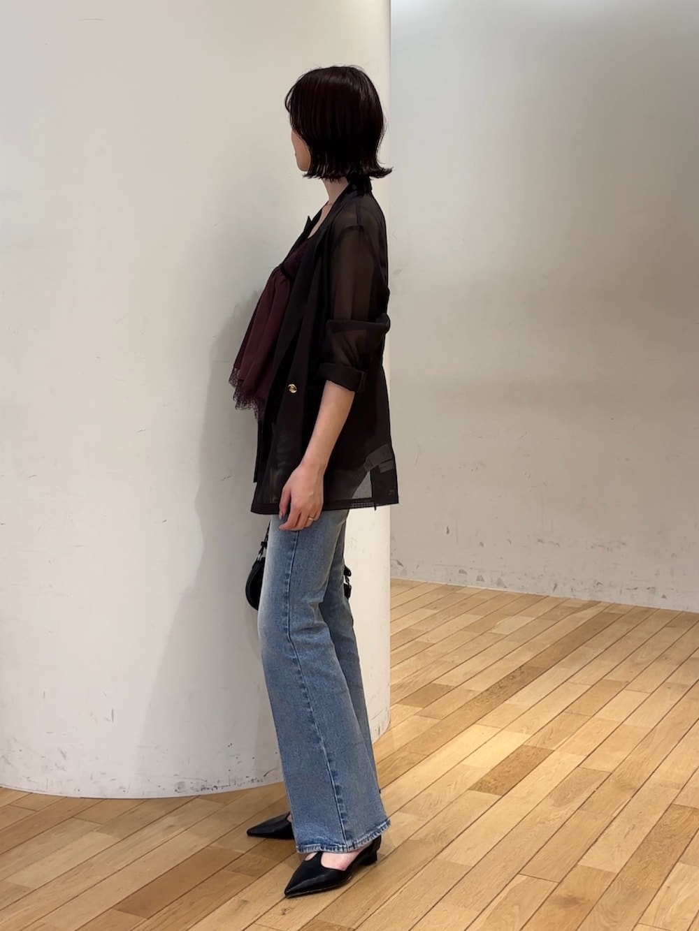 ブルー系のデニムパンツ、ブラック系のハンドバッグ、ブラック系のパンプスを着用したレディースの夏コーディネートの5枚目の写真
