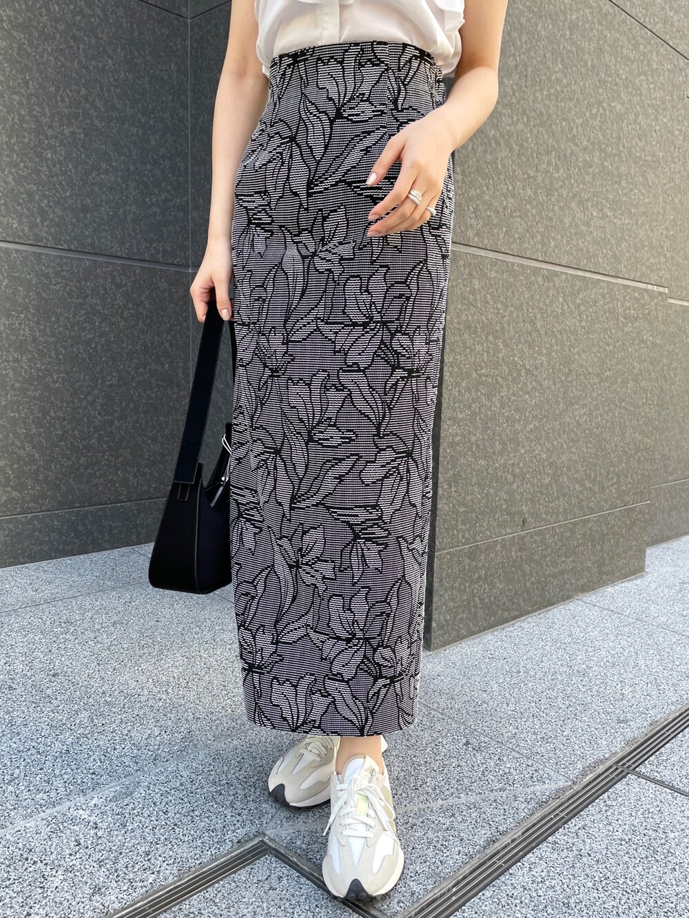 ホワイト系のシャツ/ブラウス、ブラック系のスカート、ブラック系のハンドバッグを着用したレディースの春コーディネートの7枚目の写真