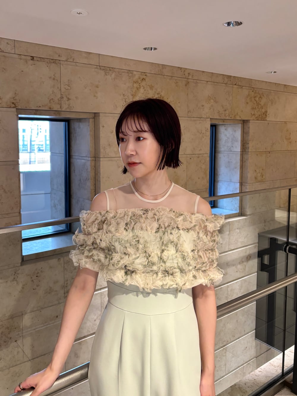 ブラック系のクラッチバッグ、ブラウン系のパンプス、グリーン系のパンツドレスを着用したレディースの秋コーディネートの5枚目の写真