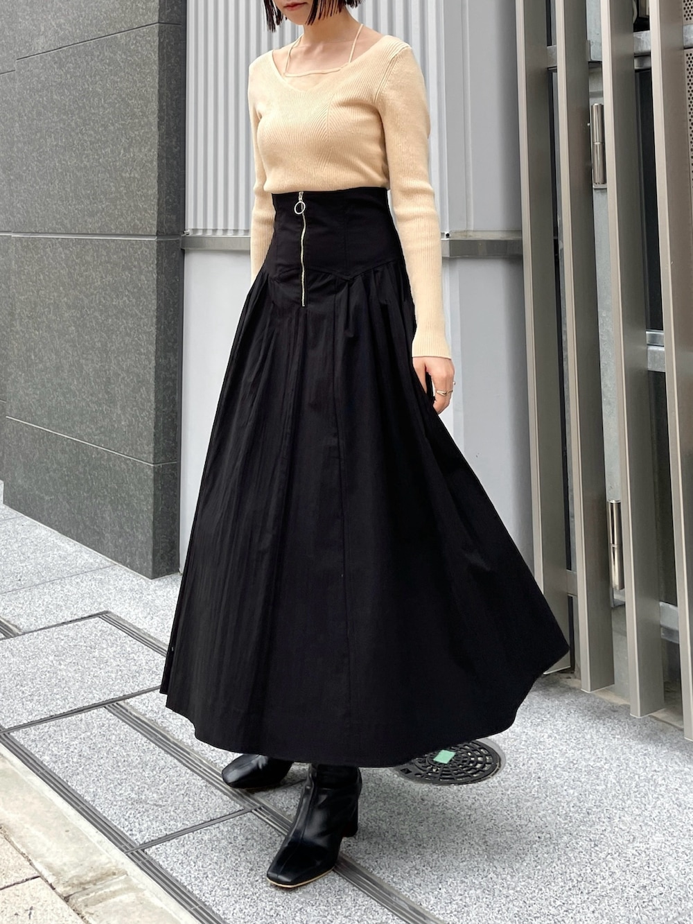 ブラック系のブーツ、ホワイト系のニット/セーター、ブラック系のスカートを着用したレディースの冬コーディネートの5枚目の写真