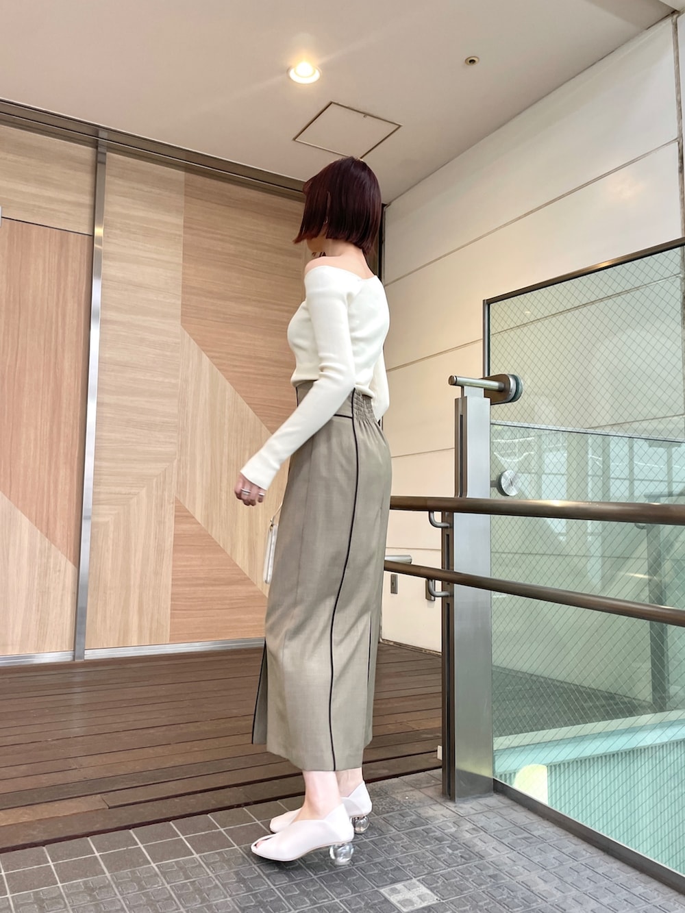 ホワイト系のパンプス、ホワイト系のニット/セーター、ブラウン系のスカートを着用したレディースの春コーディネートの4枚目の写真