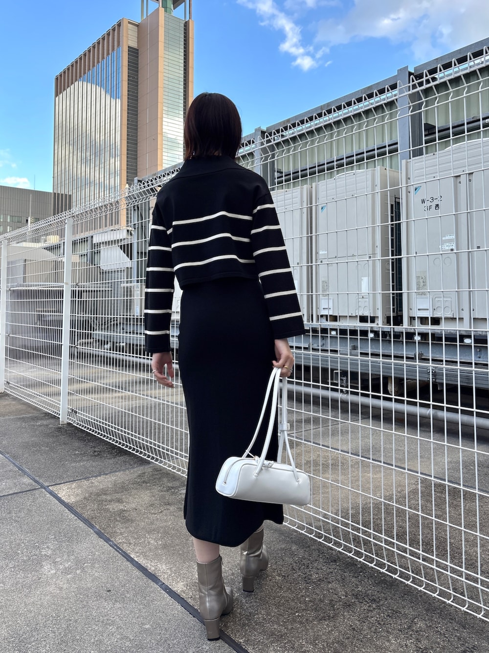 ブラック系のニット/セーター、ブラック系のスカート、グレー系のムートンコートを着用したレディースの冬コーディネートの3枚目の写真