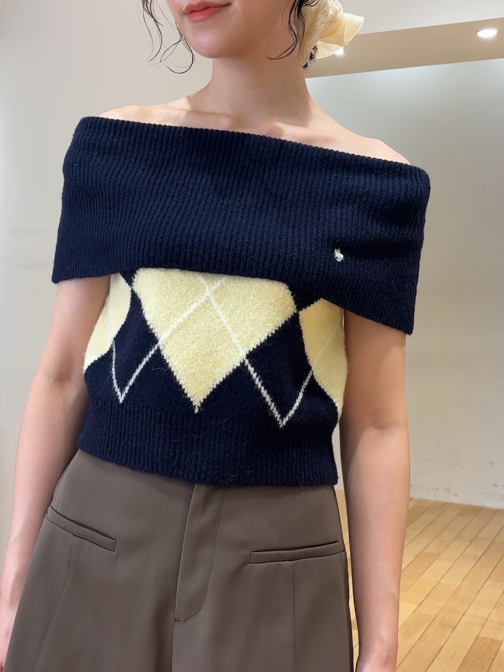 ブラウン系のその他パンツ、ブルー系のニット/セーター、ブラック系のハンドバッグを着用したレディースの夏コーディネートの7枚目の写真
