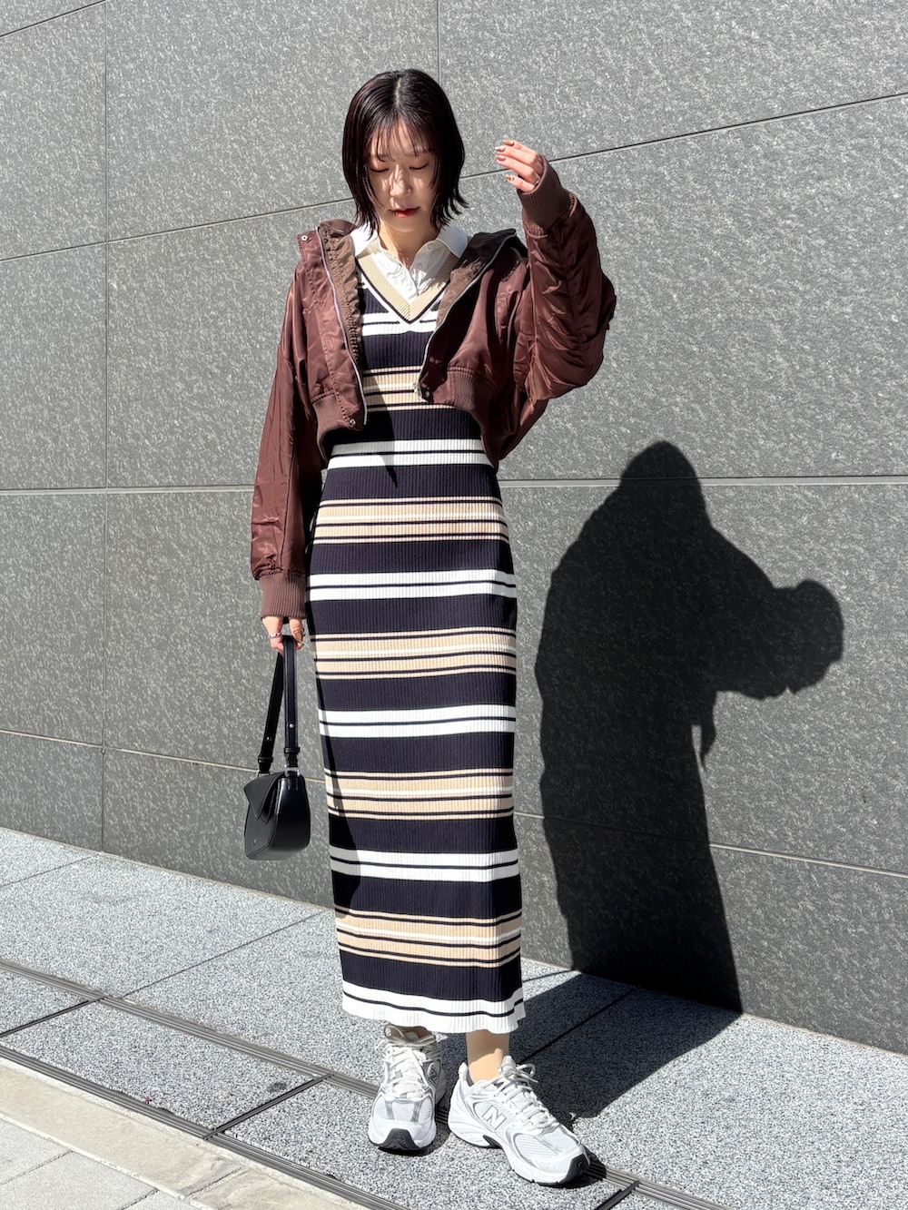 ベージュ系のワンピース、ブラック系のハンドバッグを着用したレディースの春コーディネートの6枚目の写真