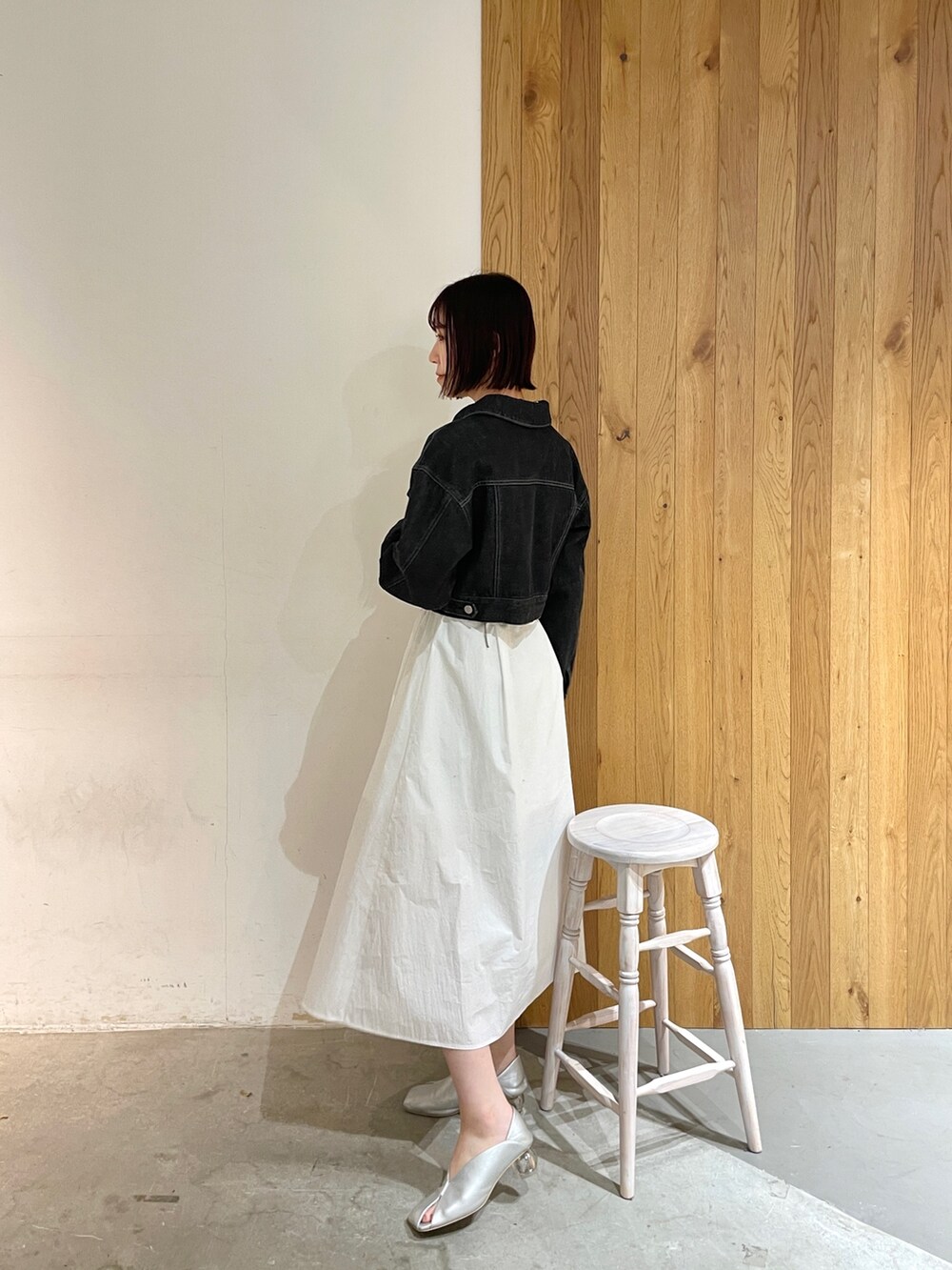 シルバー系のパンプス、ホワイト系のシャツワンピース、ブラック系のデニムジャケットを着用したレディースの冬コーディネートの7枚目の写真