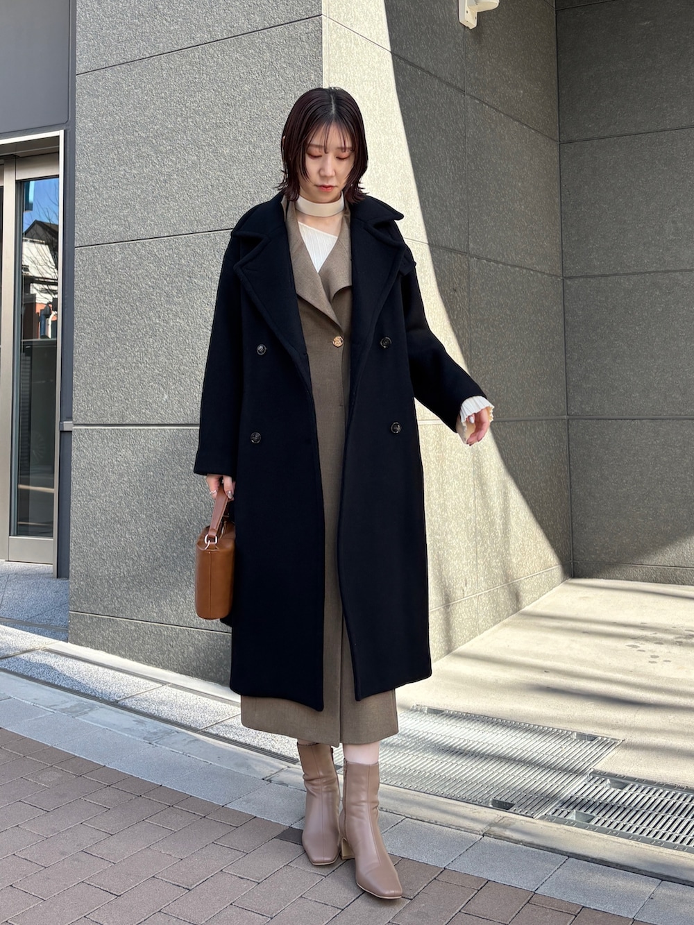 ブラウン系のワンピース、ホワイト系のニット/セーター、イエロー系のハンドバッグを着用したレディースの冬コーディネートの7枚目の写真