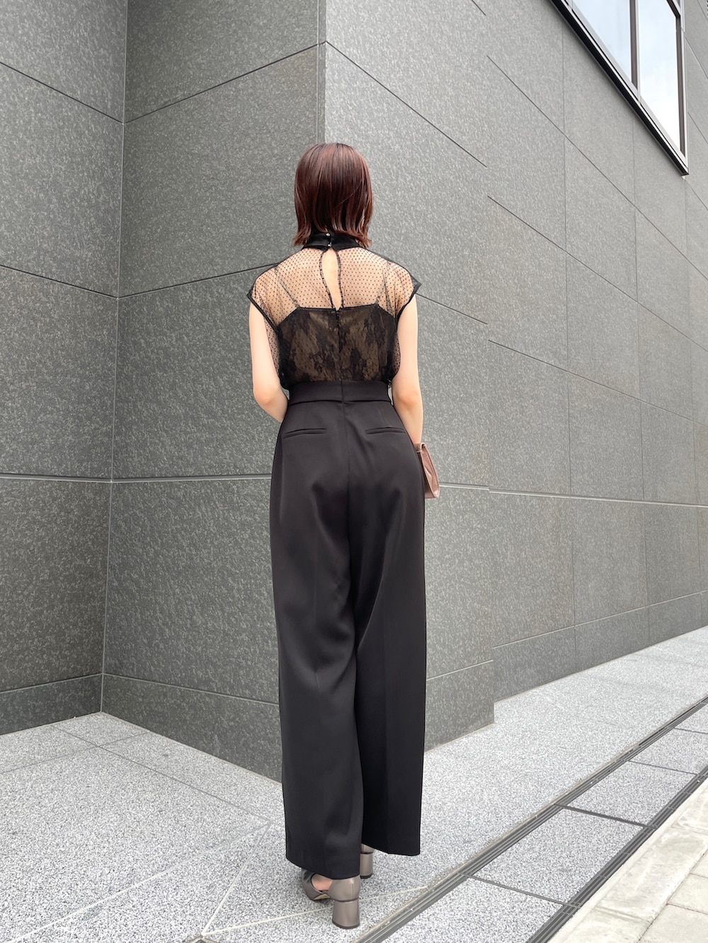 その他のパンプス、ゴールド系のクラッチバッグ、ブラック系のパンツドレスを着用したレディースの春コーディネートの4枚目の写真