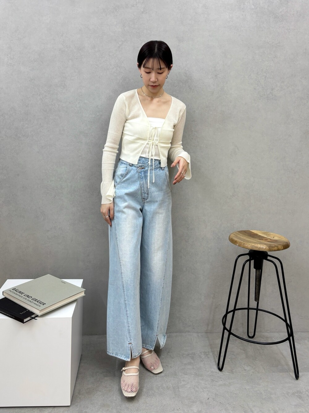 ブルー系のデニムパンツ、ホワイト系のカーディガン/ボレロ、ホワイト系のサンダルを着用したレディースの春コーディネートの2枚目の写真