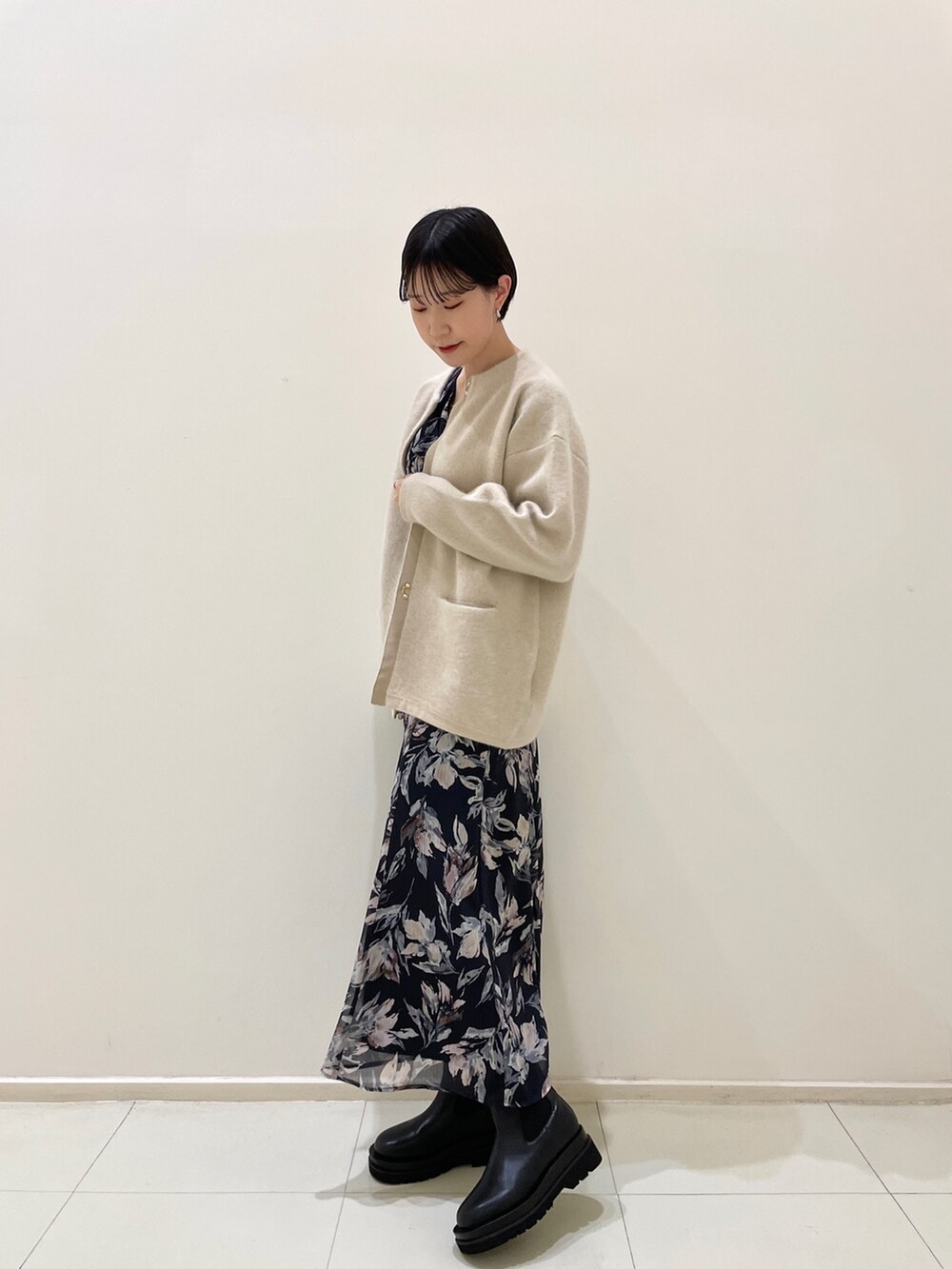 ホワイト系のカーディガン/ボレロ、ブルー系のワンピース、ブラック系のブーツを着用したレディースの冬コーディネートの3枚目の写真