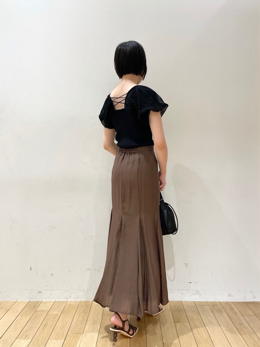 ブラウン系のスカート、ブラウン系のサンダル、ブラック系のハンドバッグを着用したレディースの夏コーディネートの3枚目の写真