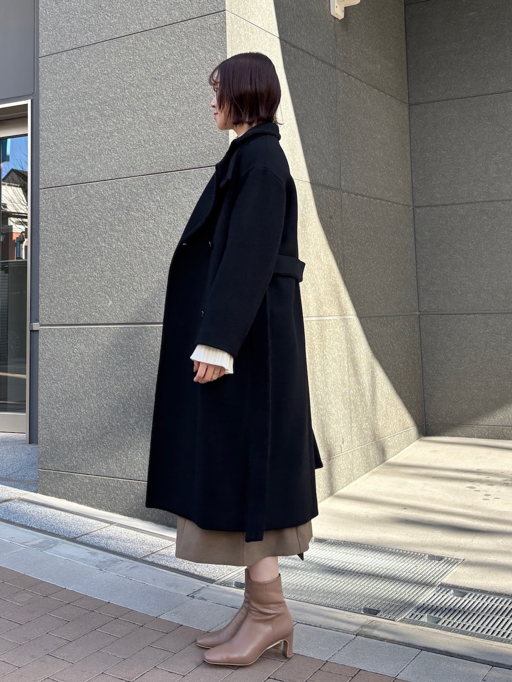 ブラウン系のワンピース、ホワイト系のニット/セーター、イエロー系のハンドバッグを着用したレディースの冬コーディネートの8枚目の写真