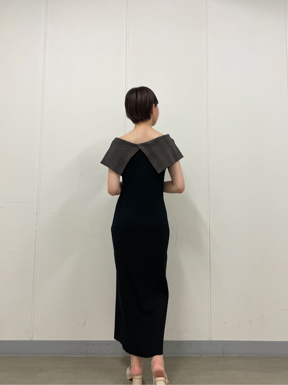 ホワイト系のサンダル、ブラック系のワンピース、シルバー系のバングル/リストバンドを着用したレディースの夏コーディネートの7枚目の写真